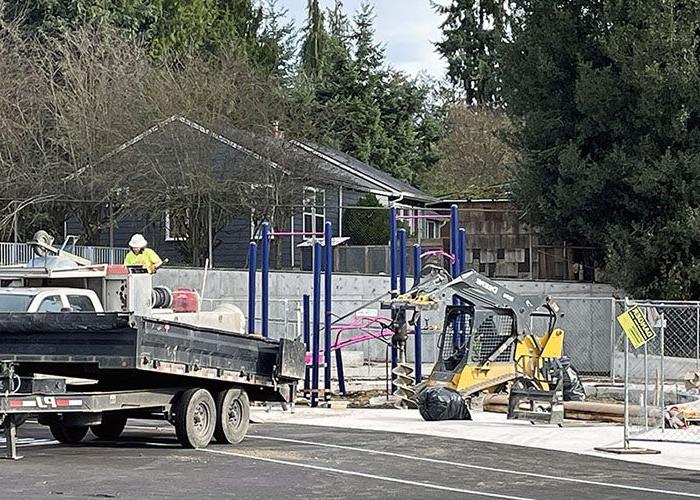 people installing a play structure with equipment