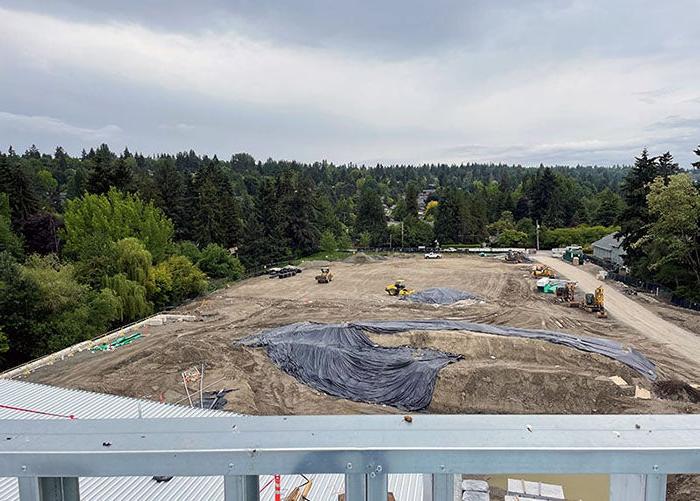 a large dirt lot with some mounds and construction grading machines